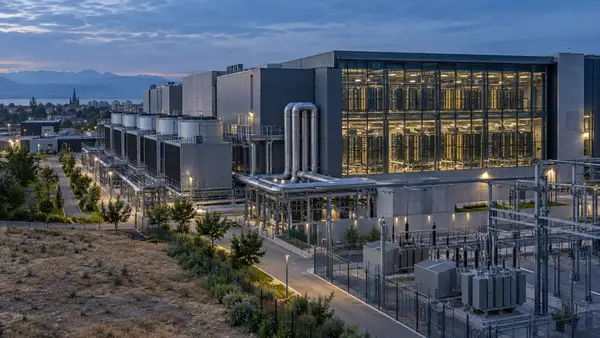 Vue d’un data center européen avec ses rangées de serveurs, ses installations de refroidissement par eau et son infrastructure électrique, illustrant la consommation énergétique et hydrique croissante de l’intelligence artificielle.