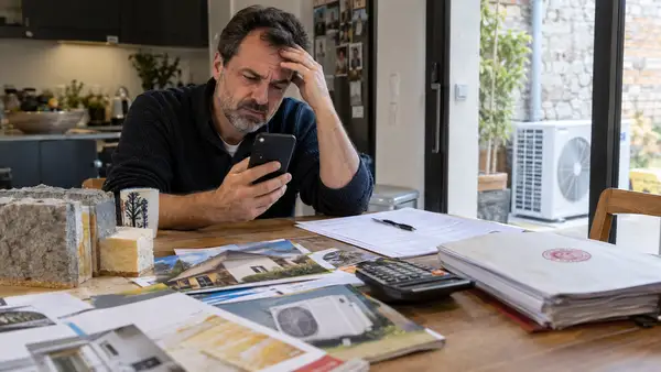 Téléphone et devis de rénovation énergétique illustrant la sanction de NEOVIA ENVIRONNEMENT pour démarchage interdit