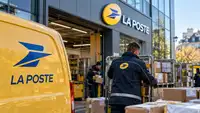Véhicule jaune de La Poste devant un centre logistique avec des agents manipulant des colis, illustration de la panne technique majeure perturbant l’envoi de courriers et de colis en France.