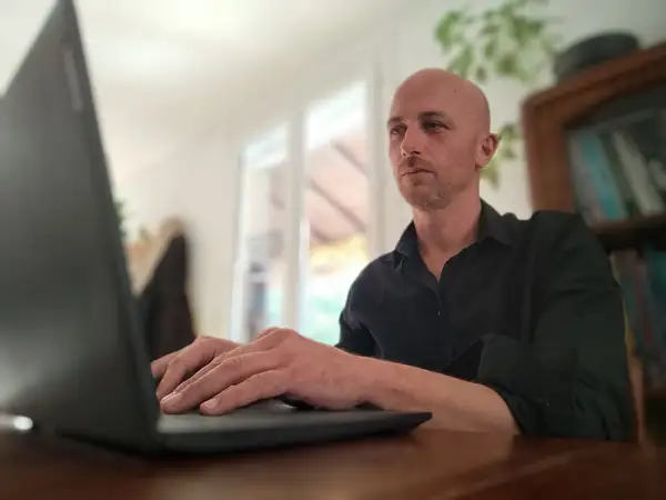 Thomas Boubagra, fondateur de Richesses Humaines Consulting, travaille sur un ordinateur portable dans le cadre d’un portrait consacré aux RH et au droit du travail dans les TPE.