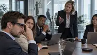 Salarié portant des lunettes connectées pendant une réunion d’entreprise sous le regard inquiet de ses collègues, illustrant les enjeux de confidentialité et d’interdiction des lunettes connectées au travail.