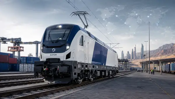 Locomotive électrique moderne inspirée d’Alstom dans un terminal ferroviaire international, symbolisant une commande industrielle de 800 millions d’euros, l’export français et le développement des infrastructures en Afrique, au Moyen-Orient et en Asie centrale.