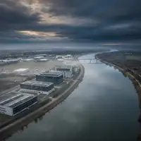 Une image de synthèse montrant une PME face à des défis climatiques, avec des graphiques de primes d'assurance en hausse et des symboles de risques naturels, illustrant l'impact sur l'assurance professionnelle des PME en 2026.