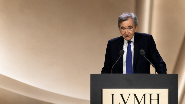 Bernard Arnault, PDG de LVMH s’exprime derrière un pupitre lors d’un événement institutionnel, illustrant le débat sur les holdings, la fiscalité des grandes fortunes et la gouvernance des grands groupes français.