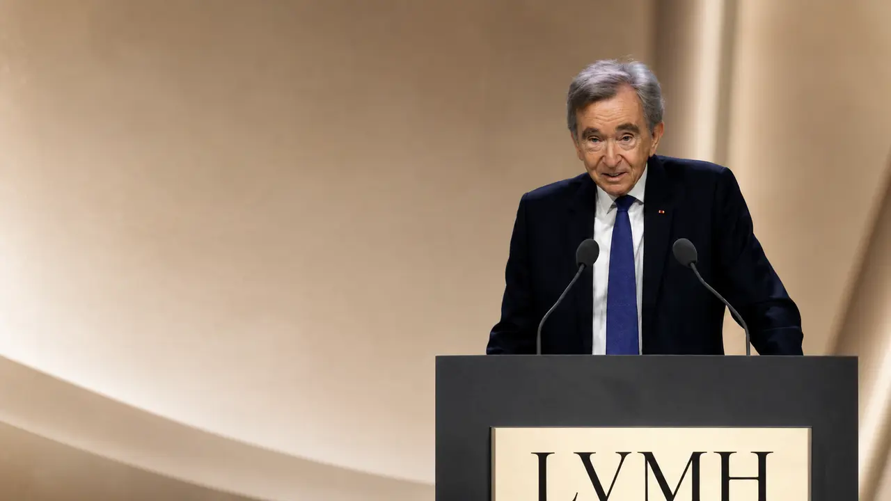 Bernard Arnault, PDG de LVMH s’exprime derrière un pupitre lors d’un événement institutionnel, illustrant le débat sur les holdings, la fiscalité des grandes fortunes et la gouvernance des grands groupes français.