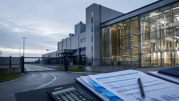 Usine industrielle d’Ÿnsect à l’arrêt, avec équipements de production visibles et documents financiers au premier plan.