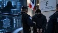 Un jeune homme menotté escorté par des policiers devant la Direction générale des Finances publiques, avec des écrans de cybersécurité en arrière-plan, illustration de l’enquête sur le piratage de la DGFiP revendiqué par ZeroBytes.