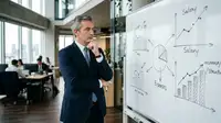 Dirigeant de PME analysant un graphique sur les salaires et l'inflation pour protéger ses marges.