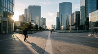 Une vue aérienne d'un quartier d'affaires moderne, avec des bureaux partiellement éclairés un vendredi après-midi, symbolisant l'impact du télétravail.