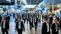 Dirigeant de PME analysant VivaTech Ia, robots, et solutions d'autonomie sur un stand.