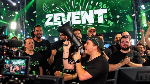 Illustration éditoriale de ZeratoR au mégaphone, entouré de streamers devant l’écran vert du ZEvent 2026 lors de la dernière édition.